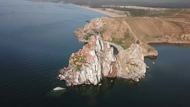 Tranquil Aerial View of the Baikal Bay Shamanka. White ship in calm bay at great lake. Olkhon Island, Baikal, Russia, Siberia. Drone footage.