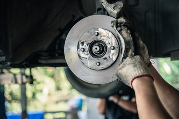 Car mechanics are replacing used brake discs.