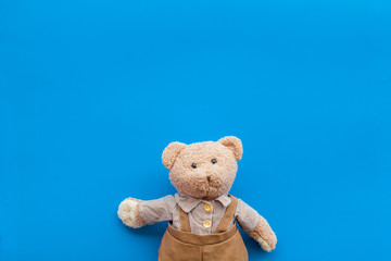 Handmade toys for newborn baby. Teddy bear. Blue background top view mockup