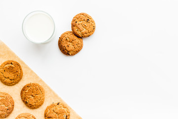 Drink milk with cookies concept. Cup of milk and fresh homemade cookies on white background top view copy space pattern