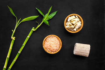 Asian spa background. Spa treatment concept. Bamboo branch, spa cosmetics on black background top view