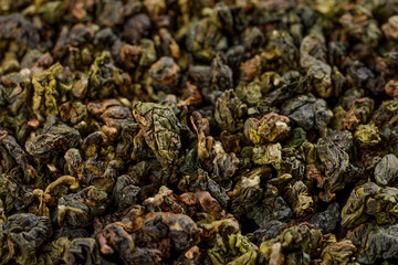 Dry green oolong tea leaf texture background. Macro.