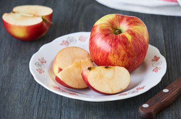 Naklejka na ściany i meble Slices of ripe red apple on a white plate