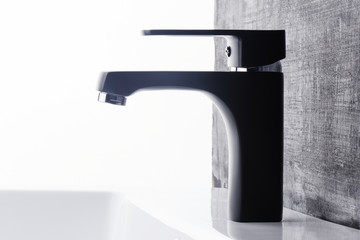 Plumbing. The interior of the bathroom. Faucet sink on black and white background.