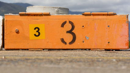 A number spray painted on a timber block to indicate a location along a pier.