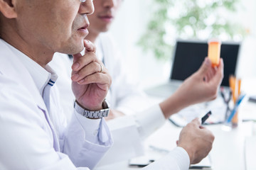 白衣の男性が前を向き薬について考えていく風景