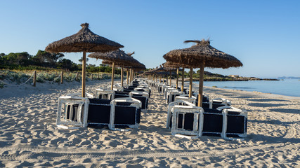 Colonia Sant Jordi, Mallorca, Spain. Beach with straw umbrellas and sunbeds in the morning without people