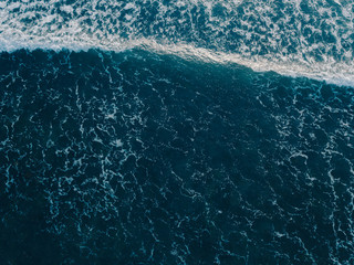 Aerial view beautiful of sea waves from drone. Stock image of blue color of ocean water, sea surface. Top view on turquoise waves, clear water surface texture.  Top view, amazing nature background