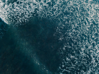 Aerial view beautiful of sea waves from drone. Stock image of blue color of ocean water, sea surface. Top view on turquoise waves, clear water surface texture.  Top view, amazing nature background