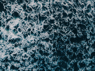 Sea aerial view, top view, amazing nature background. Blue color of the water and beautiful bright. Azure beach with turquoise waves and clear water of ocean on sunny day. Sea view from flying drone