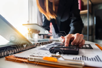 Business women are calculating daily expenses, business documents on office desk with laptop and smart phone and graph business diagram and women working at office.