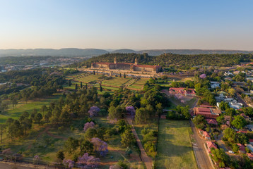 Aerial view of The Union Buildings, government offices in Pretoria, South Africa showing beautiful, manicured gardens and some blooming Jacaranda trees. - obrazy, fototapety, plakaty