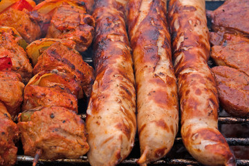 Bratwürste und Schaschlikspieße auf dem Holzkohlegrill