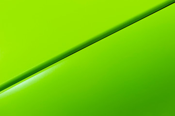 Surface of green sport sedan car metal hood, part of vehicle bodywork, steel gradient line pattern, selective focus 