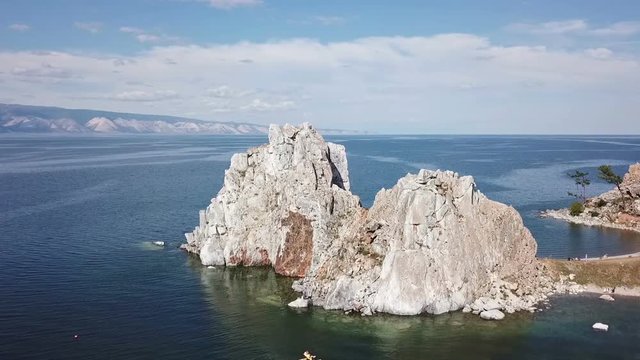 Tranquil Aerial View of the Baikal Bay Shamanka. White ship in calm bay at great lake. Olkhon Island, Baikal. Drone footage.