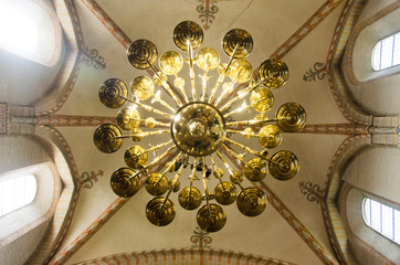Beautiful chandeliers in geometric pattern, hanging from the roof of the church