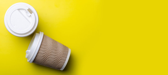 Cardboard cup of coffee on yellow background