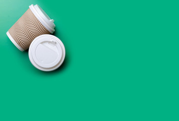 Cardboard cup of coffee on green background