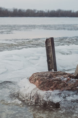 Fototapeta premium Evening on the river bank. Evening on the riverside. The frozen stones in the river coast. 