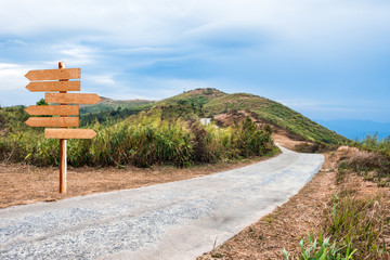 Mountain hill rural roadway with wood signboard