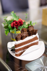 Chocolate cake and white cream with flower pot on table
