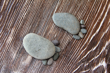 stones lie in the shape of a foot with five fingers on a wooden table macro photography