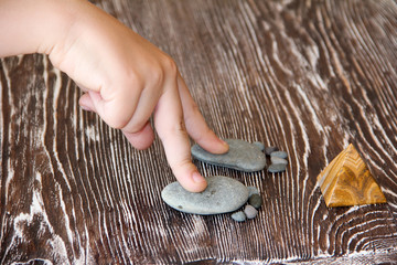 stones lie in the shape of a foot with five fingers on a wooden table macro photography