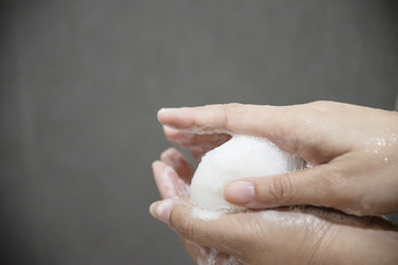 Lady hands with soap in a bath room - body health care concept