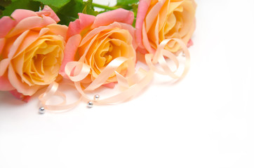 yellow-pink roses and ribbons and beads on white background 