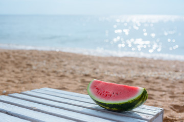 Watermelon on a background of a sandy beach and the sea.