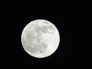 An amazing photography of the full  moon over the city of Genova by night with a great clear sky in background and some stars