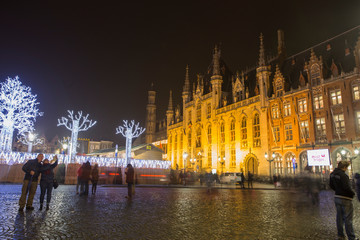 Fototapeta na wymiar Bruges, Belgium - November 24, 2018: Central Bruges Market Square by night decorated at Christmas.