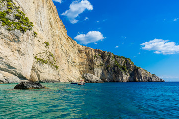 Fototapeta na wymiar Greece, Zakynthos, Tour boats in perfect azure waters next to impressive chalk cliffs