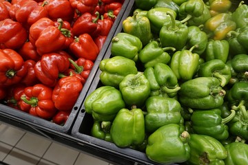 Green and red peppers display in a supermarket. 