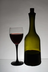 A glass of red wine and a bottle