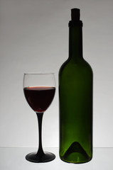A glass of red wine and a bottle