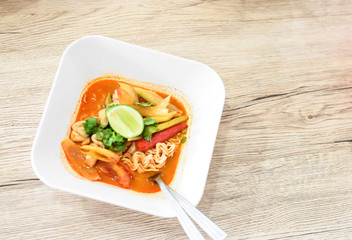 Hot Tom Yum Noodles on Vintage Wooden Background