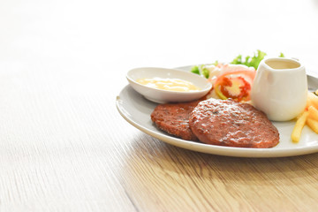 Beef steak, salad and french fries on a vintage wood background