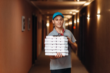 Delivery man with fresh pizza in carton boxes