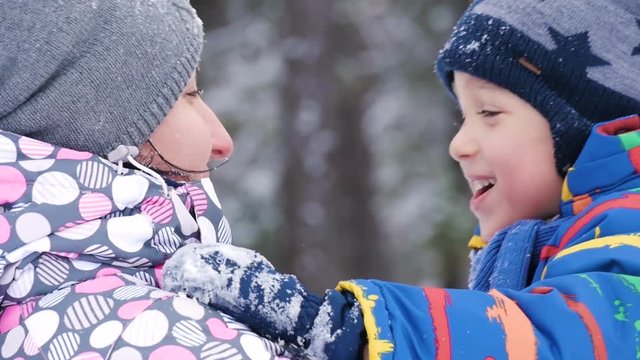 Mom and little child hug each other, showing the emotions of love, care and happiness. Relationship mother and child. Family resting in the park, on a snowy winter day. Profile of people close up.