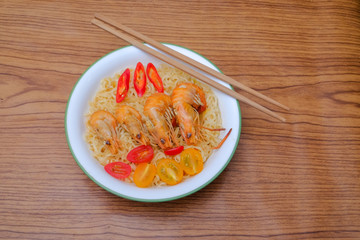 Hot and spicy instant noodle with prawn isolated on the wooden background