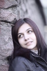 portrait of a young woman against a stone wall