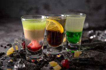 Set of Alcoholic cocktails in shot glasses (shooters). Cool drink from strong vodka, whiskey and sweet liqueurs. Easy Bartenders Recipes and Ideas
