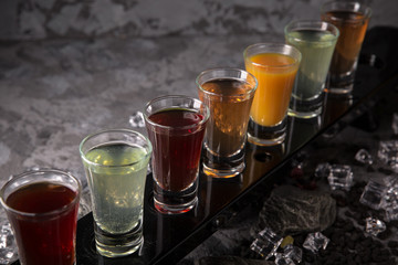 Set of Alcoholic cocktails in shot glasses (shooters). Cool drink from strong vodka, whiskey and sweet liqueurs. Easy Bartenders Recipes and Ideas