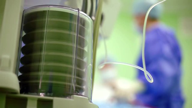 breathing apparatus in the operating room, blurred background with surgeons at work in hospital