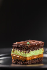 Close-up chocolate biscuit cake with pistachio cream and boiled condensed milk. Copy space.