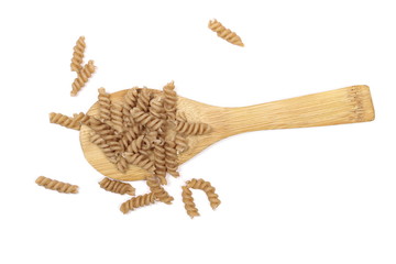Wholemeal pasta with wooden spoon isolated on white background, top view