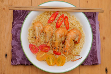 Hot and spicy instant noodle with prawn isolated on the wooden background