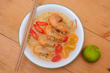 Hot and spicy instant noodle with prawn isolated on the wooden background