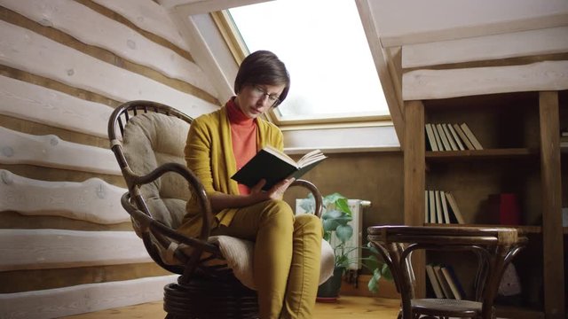 Woman reading book on attic